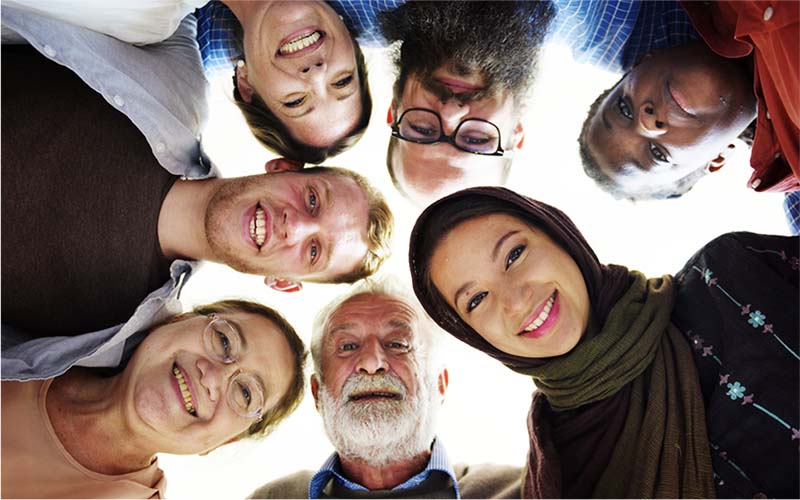 A diverse group of people gathered in a huddle